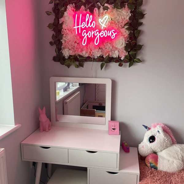 Pink LED neon sign glowing in a styled bedroom
